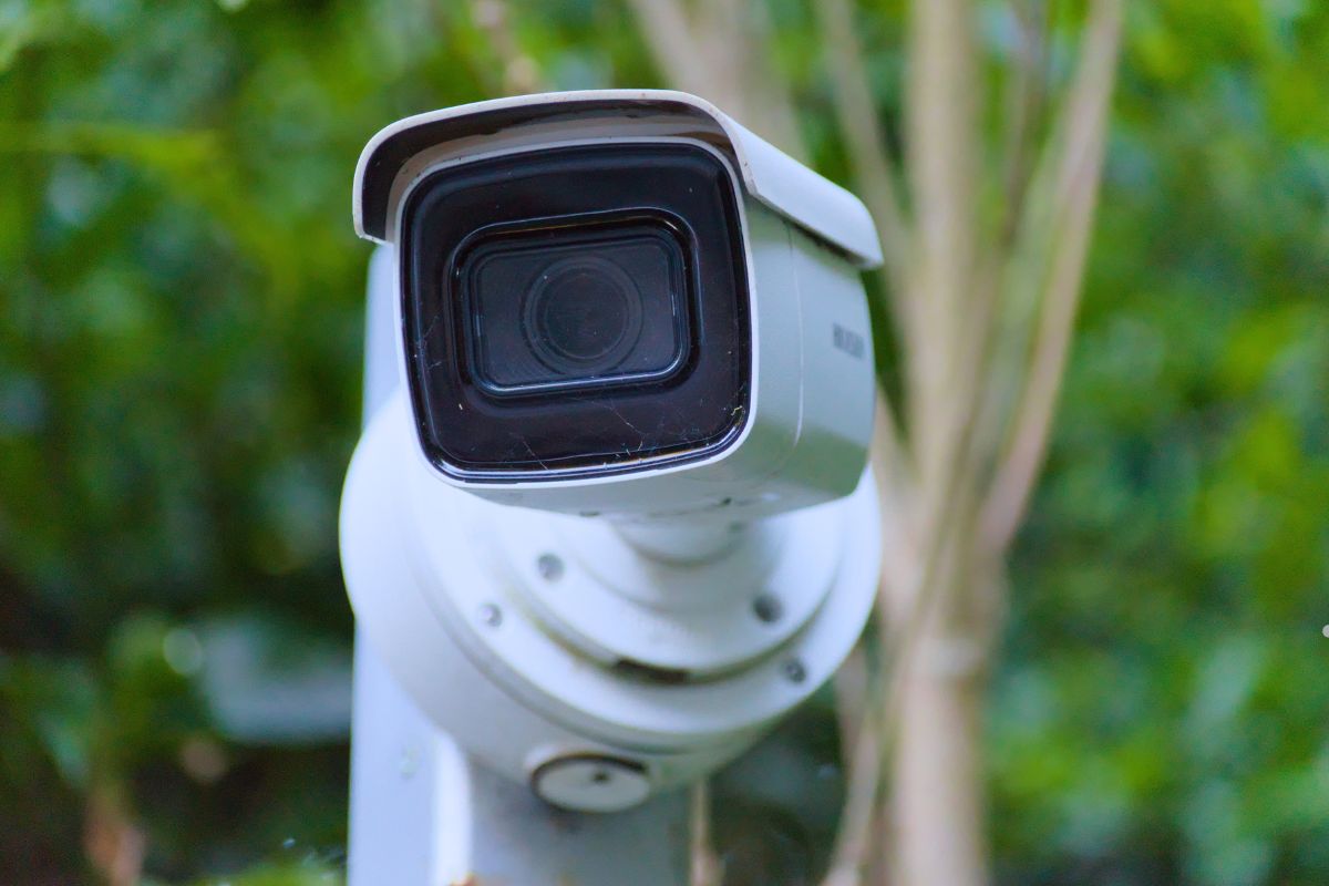 Security camera positioned in front of a lush green bush, symbolizing the importance of defining security goals.